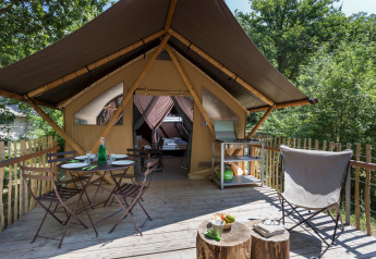 Safari tent Canadian Tent at Village Huttopia Lagoa de Óbidos, Portugal, with deck, dining set and forest view.
