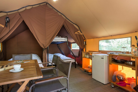 Binnenzijde van een Canadese safaritent bij Village Huttopia Lagoa de Óbidos in Portugal, met bedden en keuken.