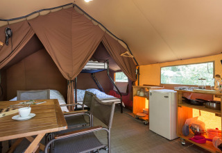 Binnenzijde van een Canadese safaritent bij Village Huttopia Lagoa de Óbidos in Portugal, met bedden en keuken.