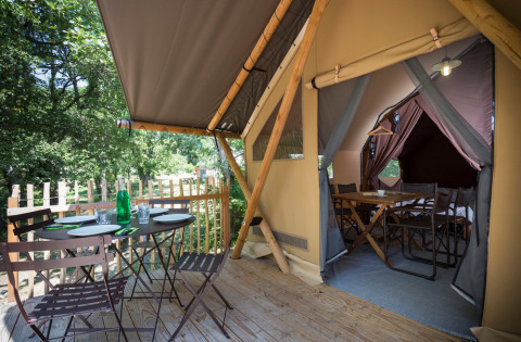 Tienda safari Canadian tent en Village Huttopia Lagoa de Óbidos, Portugal, con terraza y zona de comedor.
