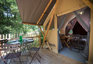 Safaritent Canadian tent bij Village Huttopia Lagoa de Óbidos in Portugal, met gezellige terras en zitplek.