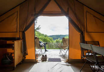 Vue depuis l’intérieur d’une tente safari Trapper au Village Huttopia Lagoa de Óbidos, Portugal, avec nature extérieure.