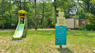 Parque infantil con tobogán y cartel informativo en Camping Seasonova L'Etang des Bois, Centre-Val de Loire.