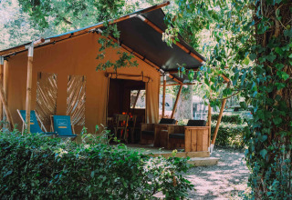 Cozy safari tent lodge at Camping Seasonova L'Etang des Bois in Centre-Val de Loire, France, surrounded by greenery.