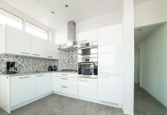 Moderne witte keuken in Pavilion van EuroParcs Veluwemeer, Nederland, met gekleurde tegels en apparaten.