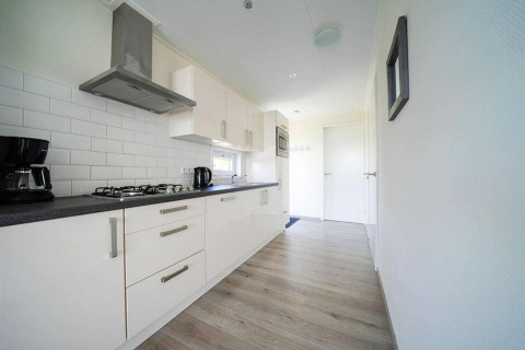 Modern kitchen in a Pavilion Waterfront lodge at EuroParcs Veluwemeer, Netherlands, sleek and bright.