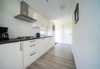 Modern kitchen in a Pavilion Waterfront lodge at EuroParcs Veluwemeer, Netherlands, sleek and bright.
