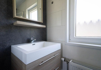 Moderno lavabo y espejo de baño en una cabaña de Pavilion Waterfront, EuroParcs Veluwemeer, Países Bajos.