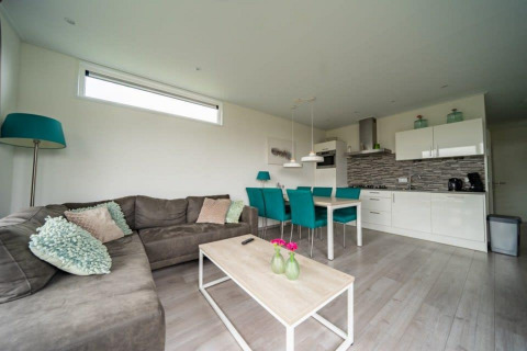 Sala de estar y cocina modernas en la lodge Pavilion Waterfront en EuroParcs Veluwemeer, Países Bajos.