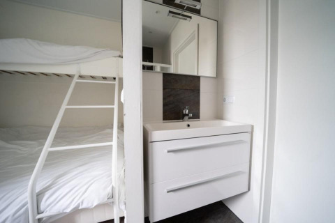 Chambre moderne avec lits superposés et lavabo au Pavilion Waterfront, EuroParcs Veluwemeer, Pays-Bas.