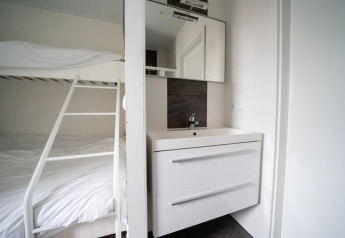 Moderne lodge met stapelbed en wastafel in Pavilion Waterfront bij EuroParcs Veluwemeer, Nederland.