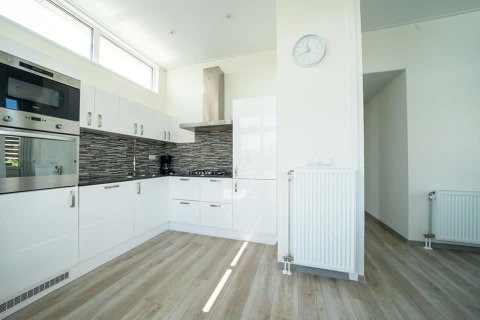 Cucina moderna al lodge Pavilion Waterfront di EuroParcs Veluwemeer, Paesi Bassi, con mobili bianchi.