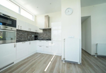 Cocina moderna en Pavilion Waterfront lodge en EuroParcs Veluwemeer, Países Bajos, con gabinetes blancos.