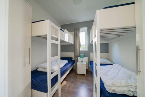 Zimmer mit Etagenbetten, moderner Einrichtung und Fenster, Pavilion Waterfront, EuroParcs Veluwemeer, Niederlande.