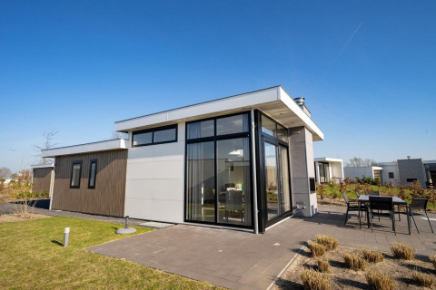 Moderne lodge Pavilion Waterfront ved EuroParcs Veluwemeer i Holland med stor glasfacade og terrasse.