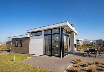 Moderne lodge Pavilion Waterfront ved EuroParcs Veluwemeer i Holland med stor glasfacade og terrasse.