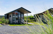 Casa tiny house moderna con facciata in vetro e terrazza presso EuroParcs Veluwemeer, Paesi Bassi.