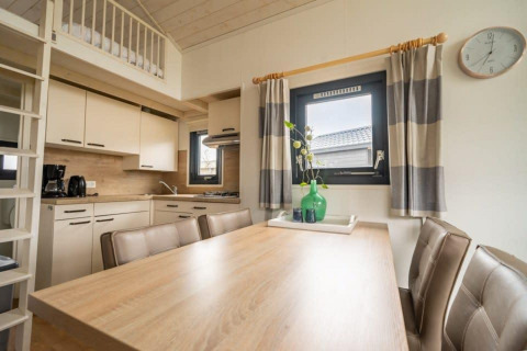 Cocina y comedor modernos de una tiny house en EuroParcs Veluwemeer, Países Bajos, con decoración acogedora.