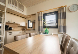 Cocina y comedor modernos de una tiny house en EuroParcs Veluwemeer, Países Bajos, con decoración acogedora.