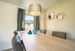 Dining area at Velthorst 4 lodge in Zuiderzee, Netherlands, with modern table, chairs, decor and pendant light.