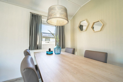 Sala da pranzo al lodge Velthorst 4 a Zuiderzee, Paesi Bassi, con tavolo moderno, sedie e lampada a sospensione.