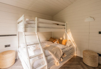 Chambre lumineuse avec lit superposé blanc et déco cosy au Lakehouse + hottub à Wilsumer Berge, en Allemagne.