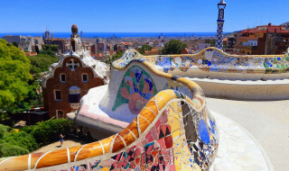 Banco de mosaico colorido y vista panorámica de la ciudad en Park Güell, Barcelona, Cataluña, España.