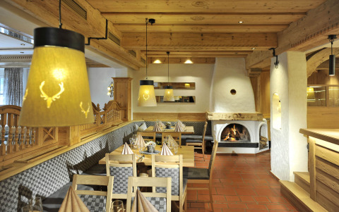Knusse eetzaal op Camping Seeblick Toni in Tirol, Oostenrijk, met houten interieur en open haard.