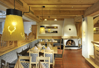 Cozy dining area at Camping Seeblick Toni in Tyrol, Austria, featuring wooden décor and a fireplace.