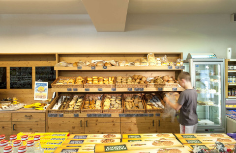 Een jongen kiest vers brood in de bakkerij van Camping Seeblick Toni, een vakantiepark in Tirol, Oostenrijk.