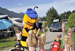 Niños juegan con una mascota de abeja en Camping Seeblick Toni, un parque vacacional en Tirol, Austria.