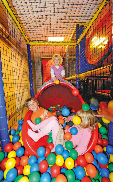 Niños jugando en una piscina de bolas y tobogán en Camping Seeblick Toni, un parque vacacional en Tirol, Austria.