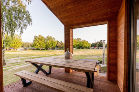 Træveranda med bænk og bord, udsigt til grønt område ved Lakehouse + hottub, Wilsumer Berge, Tyskland