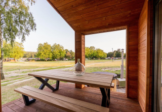 Træveranda med bænk og bord, udsigt til grønt område ved Lakehouse + hottub, Wilsumer Berge, Tyskland
