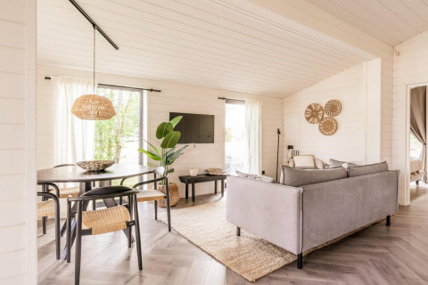 Lichte leefruimte van Lakehouse + hottub in Wilsumer Berge, Duitsland, met moderne gezellige inrichting.