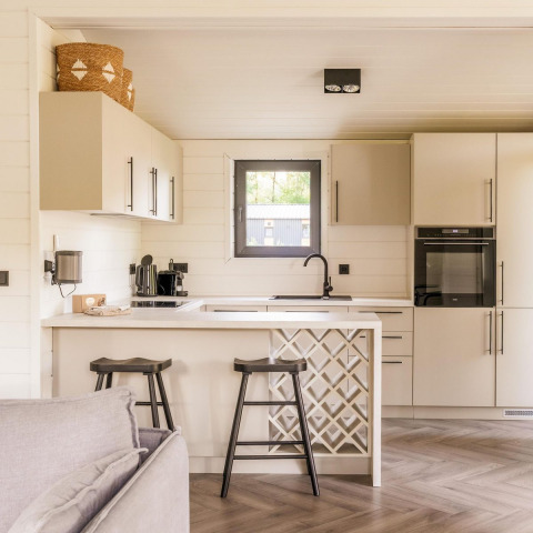 Cucina moderna al Lakehouse + hottub a Wilsumer Berge, Germania, con sgabelli e arredamento chiaro.