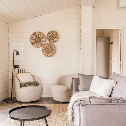 Lichte, moderne woonkamer bij Lakehouse + hottub in Wilsumer Berge, Duitsland, met sfeervolle accenten.