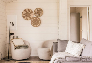 Lichte, moderne woonkamer bij Lakehouse + hottub in Wilsumer Berge, Duitsland, met sfeervolle accenten.