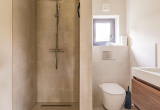 Moderne badeværelse med separat bruseniche, toilet og træskabsvaske i Lakehouse + hottub, Wilsumer Berge.