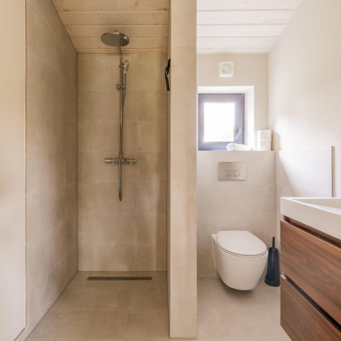 Baño moderno con ducha separada, inodoro suspendido y lavabo de madera en Lakehouse + hottub, Wilsumer Berge.