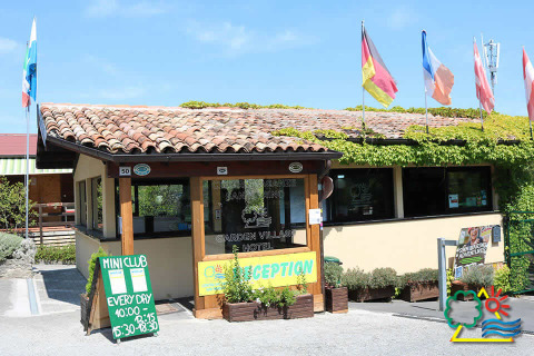 Reception del Camping Centro Vacanze San Marino, villaggio vacanze a San Marino, Italia, con bandiere sopra.