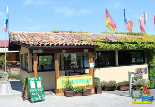 Recepción de Camping Centro Vacanze San Marino, un parque vacacional en San Marino, Italia, con banderas.