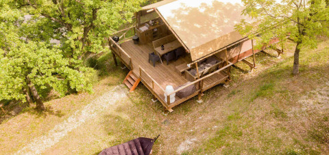 Luftaufnahme einer erhöhten Holzhütte mit Terrasse im Grünen im Camping Centro Vacanze San Marino.