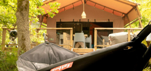 Relaxing view of a tent and deck area surrounded by trees at Camping Centro Vacanze San Marino, Italy.