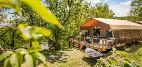 Glamping tent at Camping Centro Vacanze San Marino surrounded by greenery and natural forest setting.