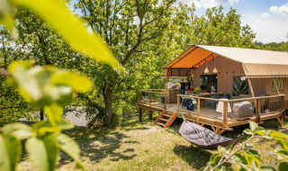 Glamping tent at Camping Centro Vacanze San Marino surrounded by greenery and natural forest setting.