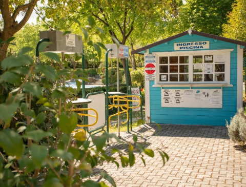 Entrée de la piscine du Camping Centro Vacanze San Marino, Italie, avec guichet de billets et tourniquets.