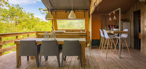 Zona de comedor exterior y cocina en la tienda Safari Desert Lodge en Camping Centro Vacanze San Marino, Italia.