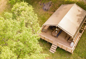 Vista aérea de la tienda safari Desert Lodge con terraza de madera en Camping Centro Vacanze San Marino, Italia.
