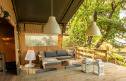 Tenda safari elegante con area relax su terrazza in legno al Camping Centro Vacanze San Marino, Italia.